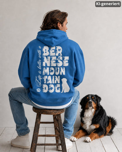 KI-generiertes Modelbild: Mann von hinten trägt Oversized-Hoodie in der Farbe "Mindful Blue" mit großem Rückenmotiv „Life is better with a Bernese Mountain Dog“ und sitzt neben einem Berner Sennenhund.