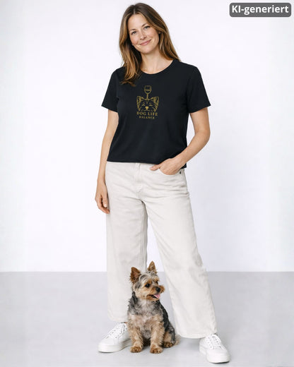 KI-generiertes Modelbild: Frau trägt schwarzes Shirt mit goldenem Dog-Life-Balance-Motiv mit Hundekopf und Weinglas neben einem Yorkshire Terrier.