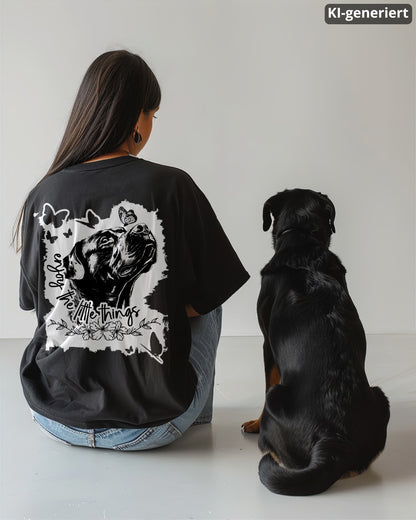 KI-generiertes Modelbild: Frau von hinten trägt schwarzes Oversized T-Shirt mit Rückenmotiv „enjoy the little things“ und sitzt neben einem Rottweiler.