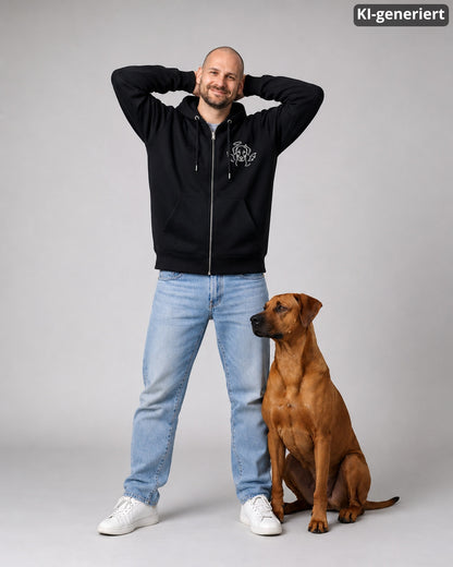 KI-generiertes Modelbild: Mann in schwarzem Zip-Hoodie mit kleinem Engelchen-Teufelchen-Hundemotiv, daneben ein sitzender Ridgeback im Studio.
