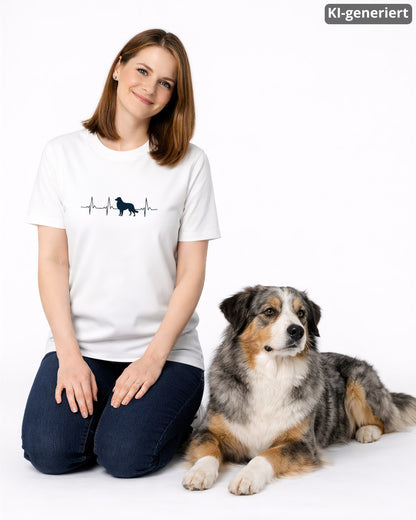 KI-generiertes Modelbild: Frau trägt weißes Shirt mit Australian-Shepherd-Herzschlagmotiv und sitzt neben einem Australian Shepherd.