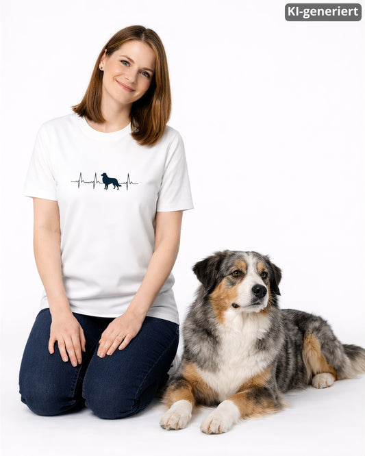 KI-generiertes Modelbild: Frau trägt weißes Shirt mit Australian-Shepherd-Herzschlagmotiv und sitzt neben einem Australian Shepherd.