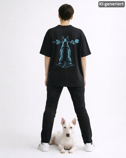 KI-generiertes Modelbild: Frau trägt schwarzes Oversized-Shirt mit Bullterrier-Rückendruck, Motiv „Silent Loyalty“, davor liegt ein Bullterrier.